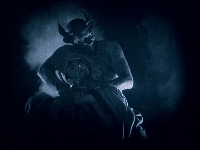 The devil strangling a woman in the night fog. Still from Häxan