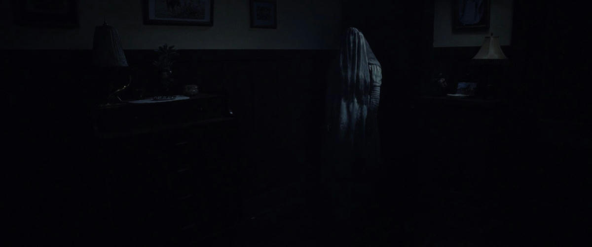 A dark interior with a ghost in the corner.