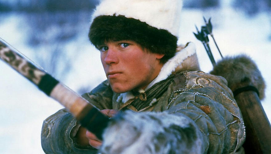 samisk gutt som sikter rett mot seeren med pil og bue.