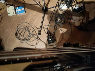 POV from a bass player down towards a messy floor with cables and some effect pedals